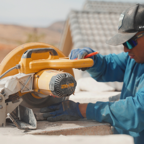 Stonemason cutting natural stone to size on a St. George, Utah job site